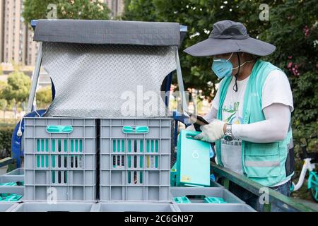 Un chargeur de batterie de vélo partagé change les batteries d'un vélo partagé dans la ville de Hefei, province d'Anhui en Chine orientale, le 4 juin 2020. Banque D'Images