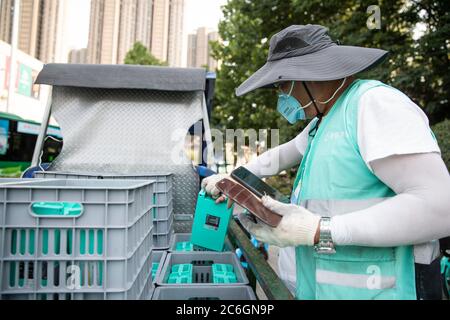 Un chargeur de batterie de vélo partagé change les batteries d'un vélo partagé dans la ville de Hefei, province d'Anhui en Chine orientale, le 4 juin 2020. Banque D'Images