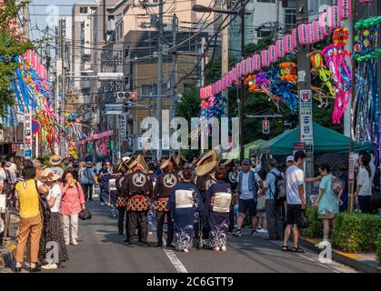 Danseurs folkloriques dans yukata coloré et amigasa chapeau de paille danse dans le festival Shitamachi Tanabata Matsuri dans la rue de Kappabashi, Tokyo, Japon. Banque D'Images