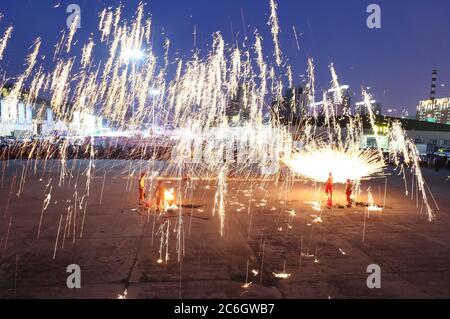 Des artistes effectuent des projections de fer fondu près de l'échangeur de l'autoroute Qinggang dans la ville de Changchun, dans la province de Jilin, dans le nord-est de la Chine, le 7 juin 2020. Banque D'Images