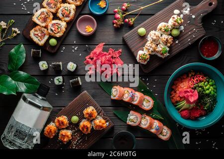 Table servie avec sushis, petits pains et plats traditionnels japonais sur fond sombre. Vue de dessus. Banque D'Images