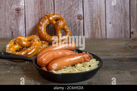 Saucisses traditionnelles allemandes bratwurst avec choucroute, et bretzels Banque D'Images