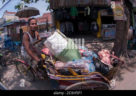 Homme en cyclo transportant de la viande et de la tête de vache sur le cyclo, Porong Sidoarjo, près de Surabaya, Java-est, Indonésie Banque D'Images