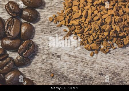 Vue macro des grains de café fraîchement torréfiés vus sur une table en bois, sur le point d'être moulu pour faire du café frais. Banque D'Images