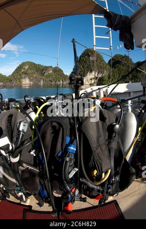 Réservoirs de plongée sur bateau à bord de bateau de plongée avec des îles de pinacle de calcaire en arrière-plan, Raja Ampat, Papouasie occidentale, Indonésie Banque D'Images