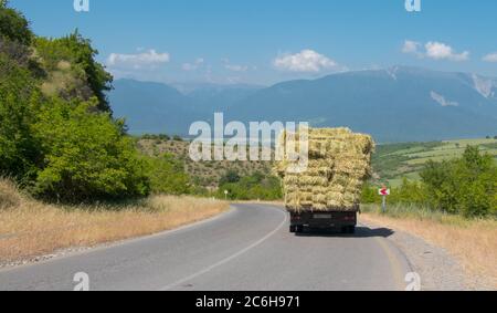 Le chariot porte des rouleaux de foin. Ivanovka mounatain village de la région azerbaïdjanaise d'Ismaili. La vie de village. Banque D'Images