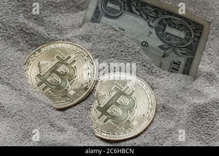 Cette image abstraite montre des bitcoins vus enterrés avec un Dollar Bill, dans le sable de silicium. Le concept ici est ancienne et nouvelle monnaies. Banque D'Images