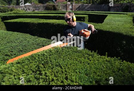 Alex McCann, de Busters Countryside Management, tond les haies de la brume de Stansted, qui est fermée au public en raison de mesures sociales de distanciation, dans le jardin clos inférieur à Stansted Park, à Stoughton, dans l'ouest du Sussex. Le labyrinthe circulaire dans les jardins la maison majestueuse classée Grade II à Stansted Park, où d'autres parties du terrain ont maintenant rouvert au public, contient plus de 500 arbres à coudre et environ un kilomètre de couverture. Banque D'Images