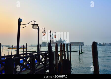 La jetée sur la place Saint-Marc avec l'église San Giorgio di Maggiore en arrière-plan au lever du soleil - Venise, Italie, Europe Banque D'Images