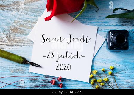 Une rose rouge et un morceau de papier avec le texte Saint George Day 2020 juillet 23e en catalan, une fête qui a généralement lieu le 23 avril en Catalogne, en Espagne, et Banque D'Images