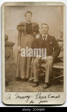 Vers 1890s. Photo à la carte de visite d'un couple victorien. Une légende manuscrite ci-dessous : « un joyeux Noël pour vous » Banque D'Images