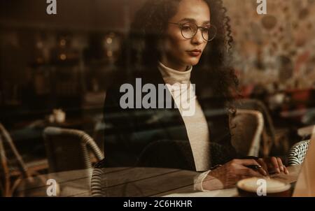 Femme assise au café et travaillant sur son ordinateur portable. Femme d'affaires travaillant dans un café. Banque D'Images