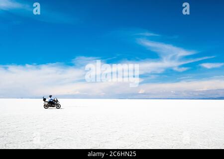 Tourisme avec équipement à moto au soleil Salar de Uyuni Banque D'Images