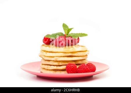 Crêpes aux framboises sur une assiette rose et sur un fond blanc Banque D'Images