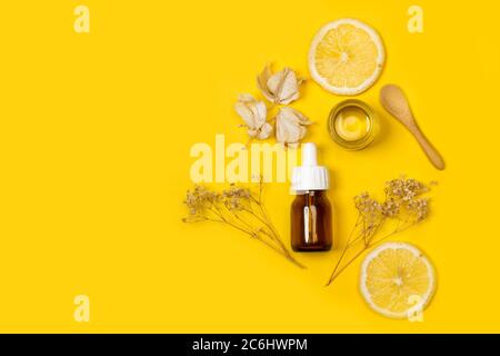 Compte-gouttes d'huile pour la peau sur fond jaune dans une vue de dessus Banque D'Images