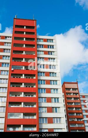 Blocs d'appartements faits pendant l'ère du socialisme dans le bloc est. Façade d'architecture de couleur rouge vif. Prise de vue en angle bas avec ciel bleu Banque D'Images