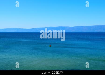 Un bateau à aubes sur l'eau près de Shaman Rock sur l'île d'Olkhon, lac Baikal, Russie Banque D'Images