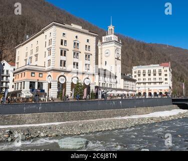 Sotchi, Russie - 4 mars 2020 : station de ski Rosa Khutor. Vue sur la rivière Mzymta et l'hôtel de ville avec horloge sur la place Rosa. Paysage urbain Banque D'Images