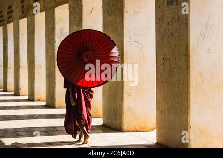 Bagan,Mandalay/ Myanmar- 01/20/2019: Jeune moine débutant marchant le long de la salle des colonnes sur le chemin du temple de Shwezigon Paya Banque D'Images