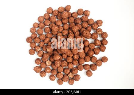 Groupe de cornflakes de chocolat ronds isolés sur fond blanc. Aliments croquants bruns Banque D'Images