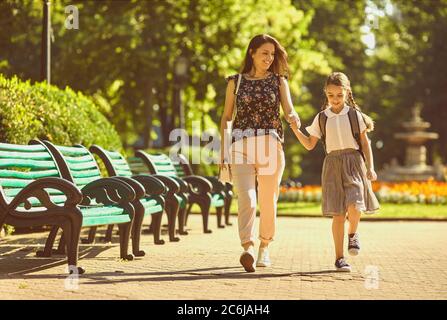 Retour à l'école. Bonne mère et fille vont à l'école le matin. Banque D'Images