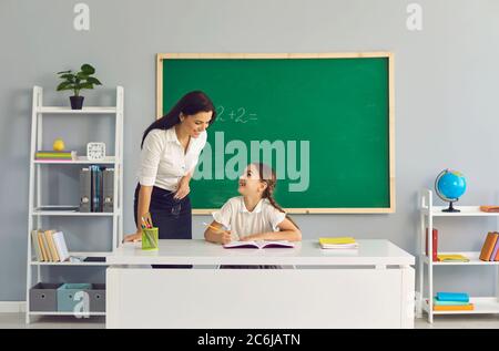 Professeur enseigne une écolière dans la salle de classe. Retour à l'école. Banque D'Images