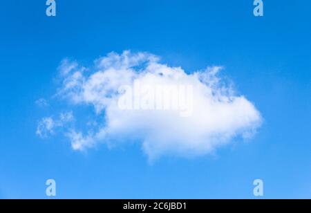 Un petit nuage blanc sur ciel bleu clair. Cumulus isolé Banque D'Images