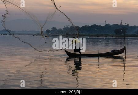 Hommes pêchant avec filet triangulaire tôt le matin au lever du soleil près du légendaire pont U-Bein, sur le lac peu profond Taungthamanin, Amarapura, Mandalay, Myanmar Banque D'Images