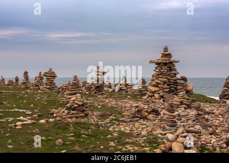 Cairns sur Castle point, Île Sainte de Lindisfarne, Northumberland, Angleterre, Royaume-Uni: En conflit avec l'éthique Leave No Trace Banque D'Images