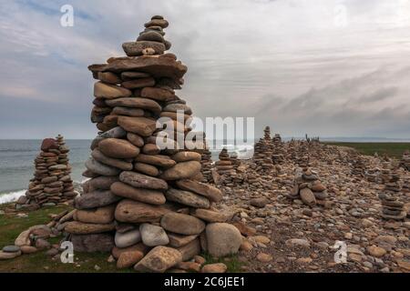 Cairns sur Castle point, Île Sainte de Lindisfarne, Northumberland, Angleterre, Royaume-Uni: En conflit avec l'éthique Leave No Trace Banque D'Images