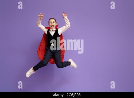 Joyeux Halloween ! Joli petit Dracula sur fond violet. Banque D'Images