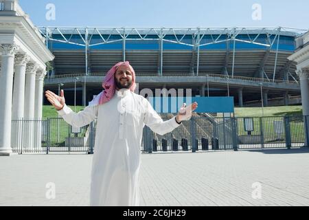 Riche portrait d'homme arabe lors de l'achat de biens immobiliers, stade en ville. Ethnicité, culture, inclusion, diversité. Homme d'affaires confiant dans les vêtements traditionnels faisant une affaire réussie. Finances, économie. Banque D'Images