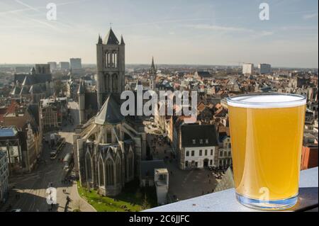 Verre de bière belge légère contre la grande cathédrale de Gand, Belgique. Vue depuis le dessus de Gand, Belgique Banque D'Images