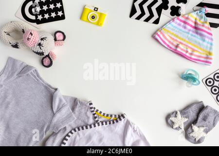 Composition avec accessoires pour bébé sur fond blanc. Unisex thème neutre avec douche de bébé ou Nouveau-né concept de pépinière avec des vêtements de bébé, jouets, Visio Banque D'Images