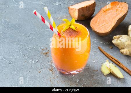 Smoothie de patate douce à la cannelle et au gingembre sur fond gris. Concept alimentaire sain et sans gluten. Copier l'espace pour le texte Banque D'Images