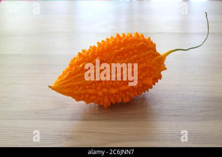 Momordica charantia isolé sur un fond en bois. Fruits entiers mûrs de Momordica charantia, également connu sous le nom de melon amer ou de courge amère sur un bois Banque D'Images