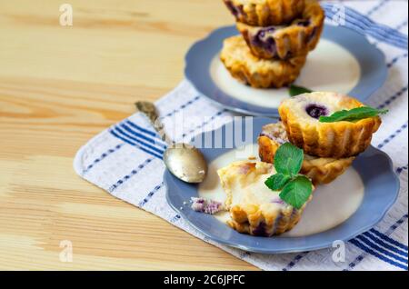 Muffins faits maison au fromage cottage avec myrtilles et menthe sur fond de bois naturel Banque D'Images