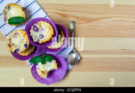 Muffins faits maison au fromage cottage avec myrtilles sur fond de bois naturel. flat lay, espace copie Banque D'Images