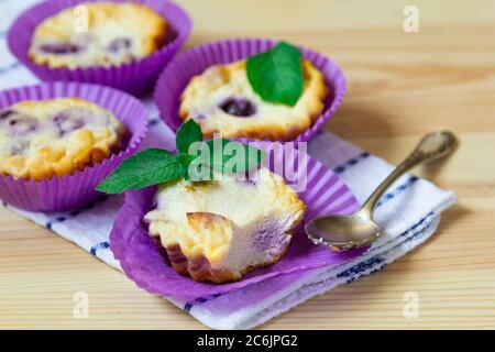 Muffins faits maison au fromage cottage avec myrtilles et menthe sur fond de bois naturel Banque D'Images