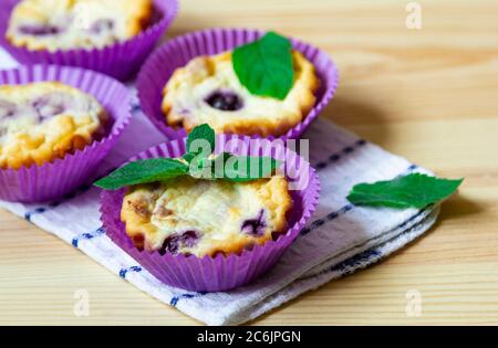 Muffins faits maison au fromage cottage avec myrtilles et menthe sur fond de bois naturel Banque D'Images