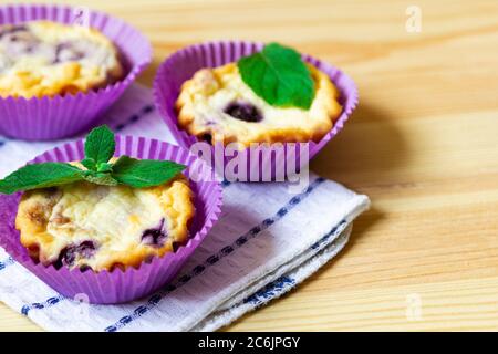 Muffins faits maison au fromage cottage avec myrtilles et menthe sur fond de bois naturel Banque D'Images