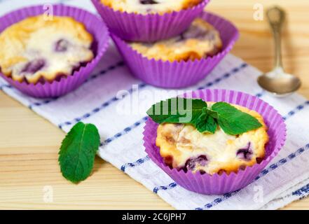 Muffins faits maison au fromage cottage avec myrtilles et menthe sur fond de bois naturel Banque D'Images