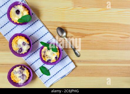 Muffins faits maison au fromage cottage avec myrtilles sur fond de bois naturel. flat lay, espace copie Banque D'Images