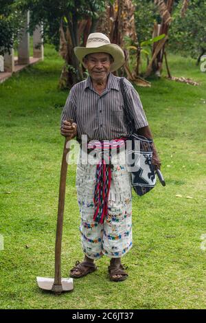 Guatemala, département de Solola, San Pedro la Laguna, UN fermier maya en robe traditionnelle pose avec sa houe. Banque D'Images