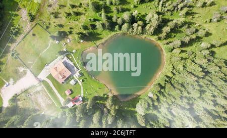 Lac alpin en été entouré par une belle forêt, vue aérienne en hauteur. Banque D'Images