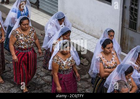 Guatemala, Département de Solola, San Pedro la Laguna, procession catholique de la Vierge de Carmen. Femmes en robe traditionnelle maya avec des lmantillas blanches brodées sur leur tête. Banque D'Images