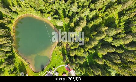 Lac alpin en été entouré par une belle forêt, vue aérienne en hauteur. Banque D'Images