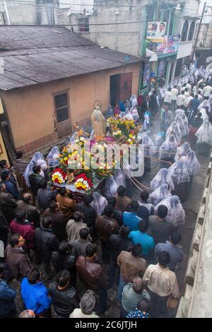 Guatemala, Département de Solola, San Pedro la Laguna, les hommes suivent la procession catholique de la Vierge de Carmen. Les femmes en robe traditionnelle maya avec des mantillas blanches sur leur tête. Les femmes portent l'image de la Vierge dans la procession. Une autre femme tient les cintas ou les rubans. Banque D'Images