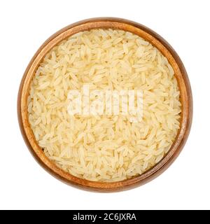 Riz à grains longs étuvé dans un bol en bois. Le riz converti est également appelé riz facile à cuire, partiellement bouilli dans la cosse par trempage, cuisson à la vapeur et séchage Banque D'Images