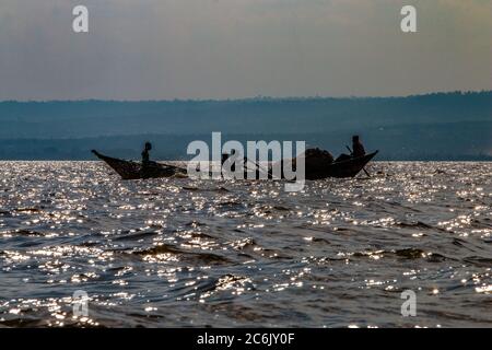 Silhouette de pêcheur dehors pour la journée à jeter leurs filets sur le bord sud du lac Victoria au Kenya Banque D'Images